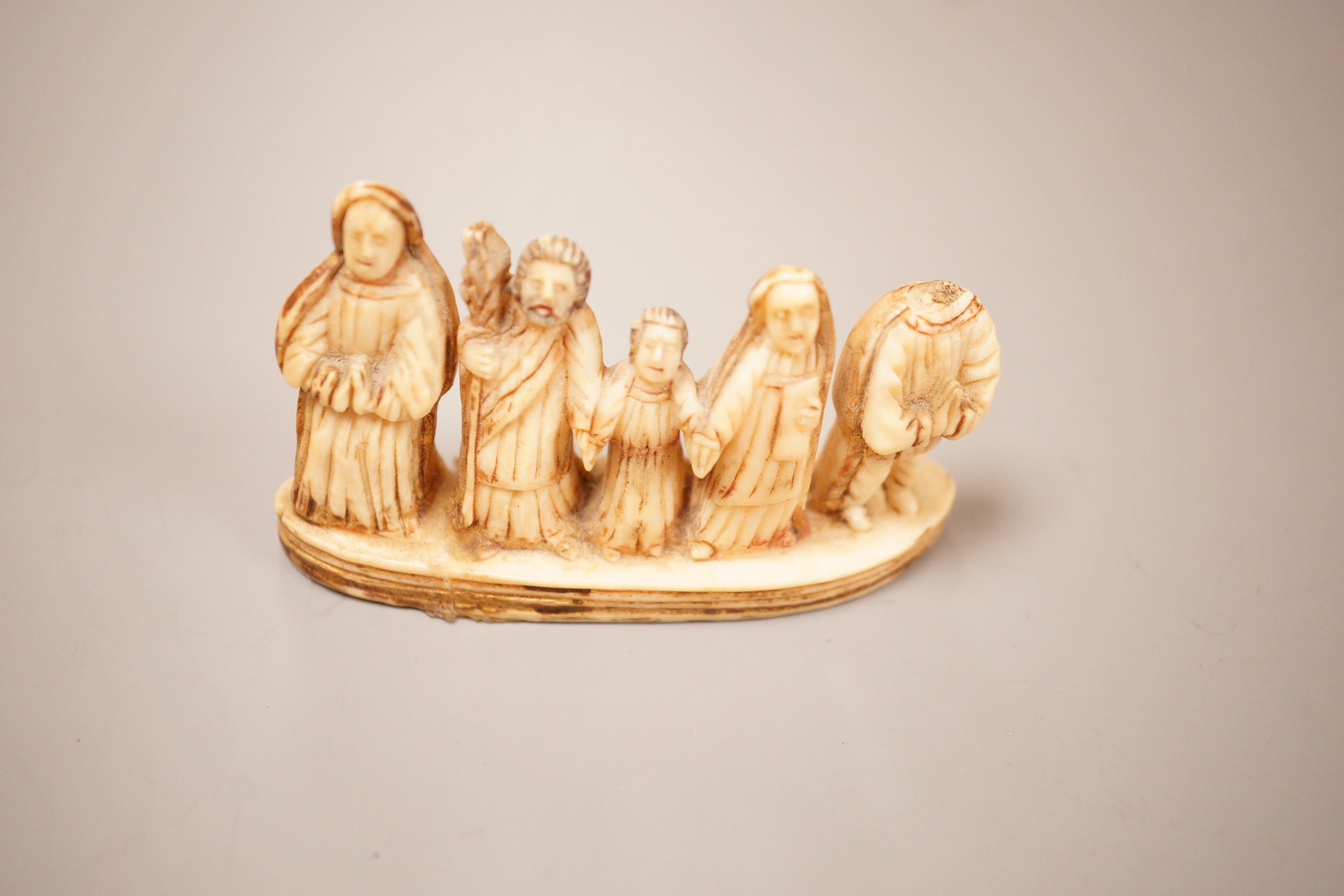 An Inuit whale tooth carving, 19th century, 8cm long, and a marine ivory religious group, possibly Goa